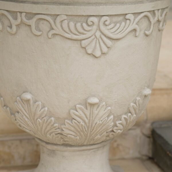 A white urn with a decorative design on it.