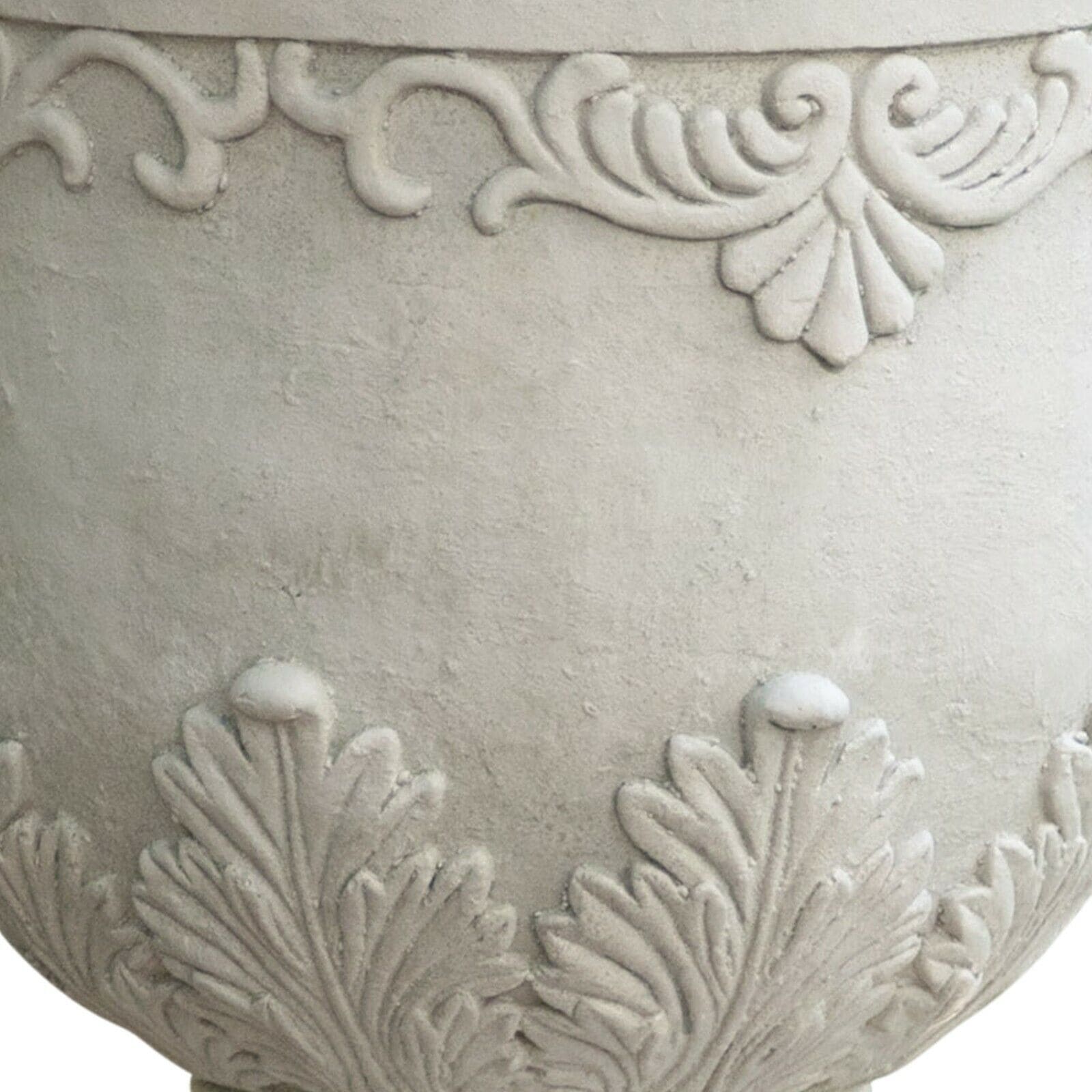 A white planter with a decorative design on it.