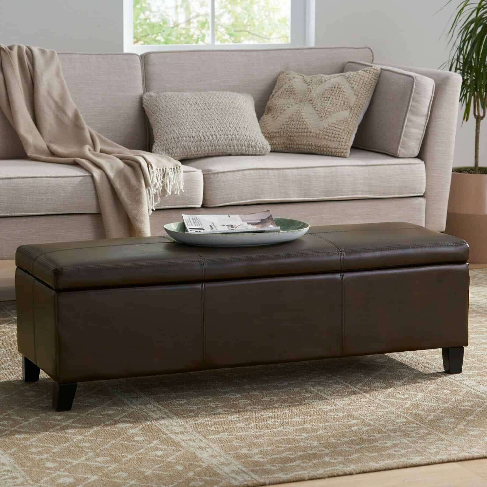 A brown leather storage ottoman in a living room.