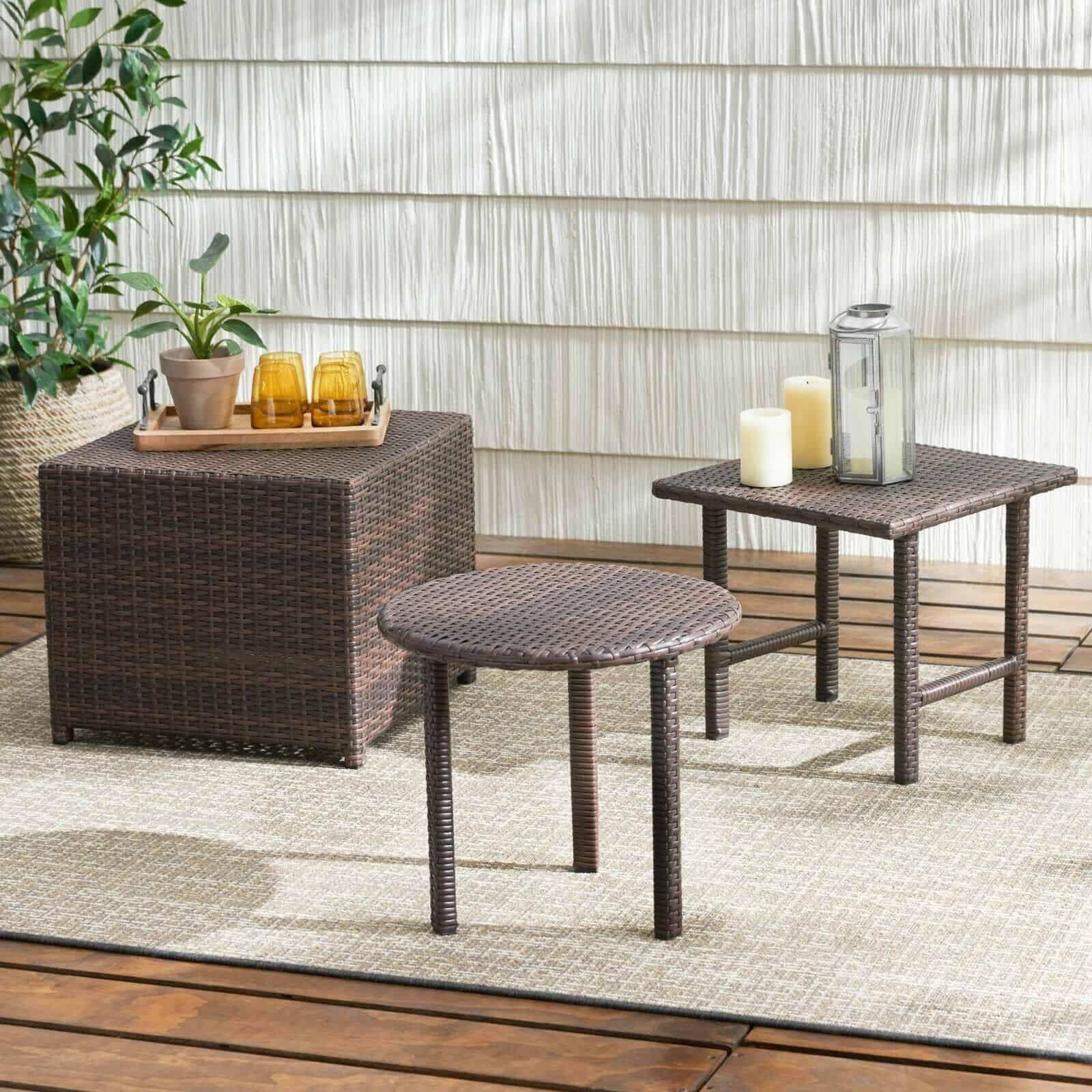 Two wicker side tables on a wooden deck.