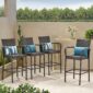 Four outdoor wicker bar stools with blue cushions.