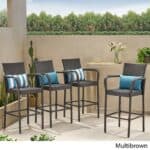 Four outdoor wicker bar stools with blue cushions.