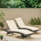 Two outdoor chaise loungers on a patio.