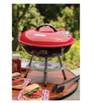 A bbq grill on a table with burgers on it.