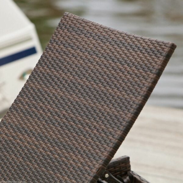 A brown wicker lounge chair on a dock.