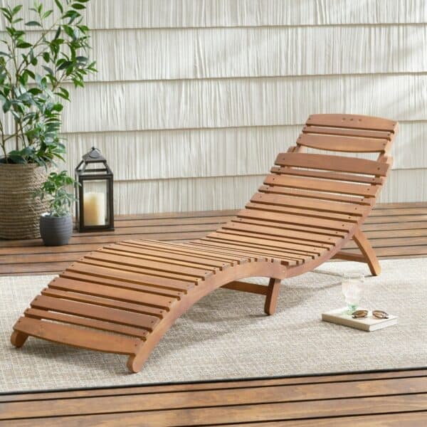 A wooden chaise lounge on a wooden deck.