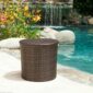 A wicker side table in front of a pool.