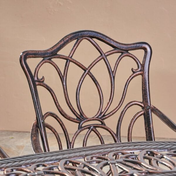 A close up of an ornate patio table and chairs.
