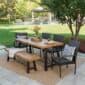 A patio set with a wooden table and chairs.