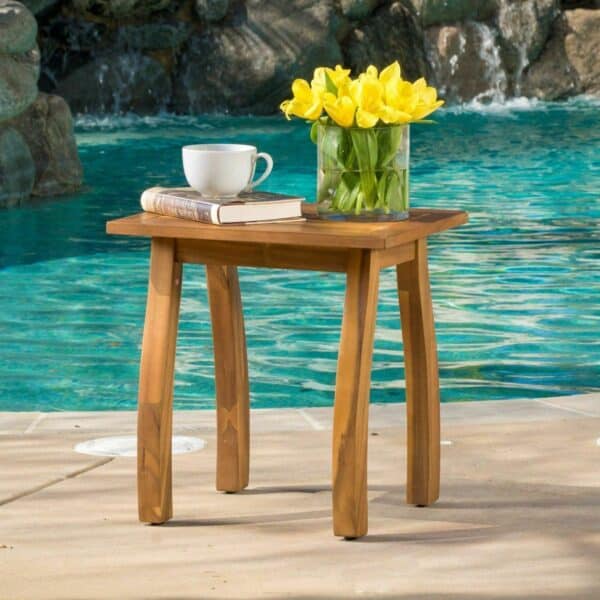 A table with a cup of coffee next to a pool.