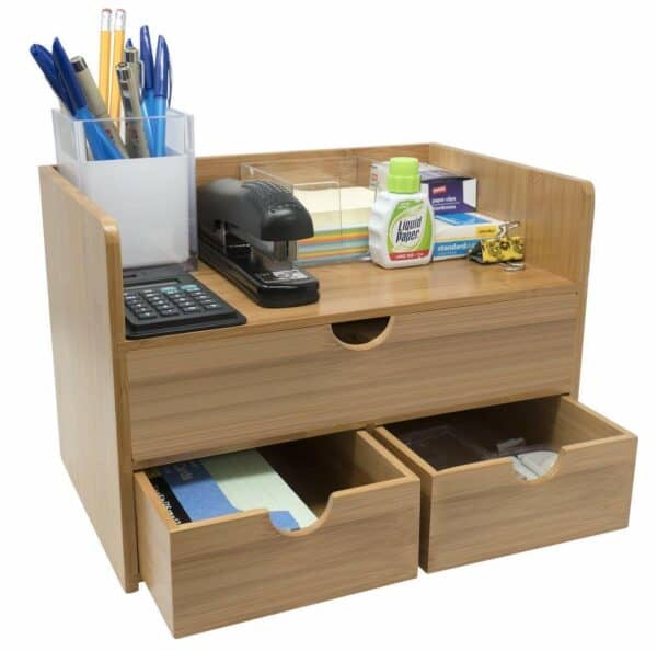A wooden desk with a few drawers and a stapler.