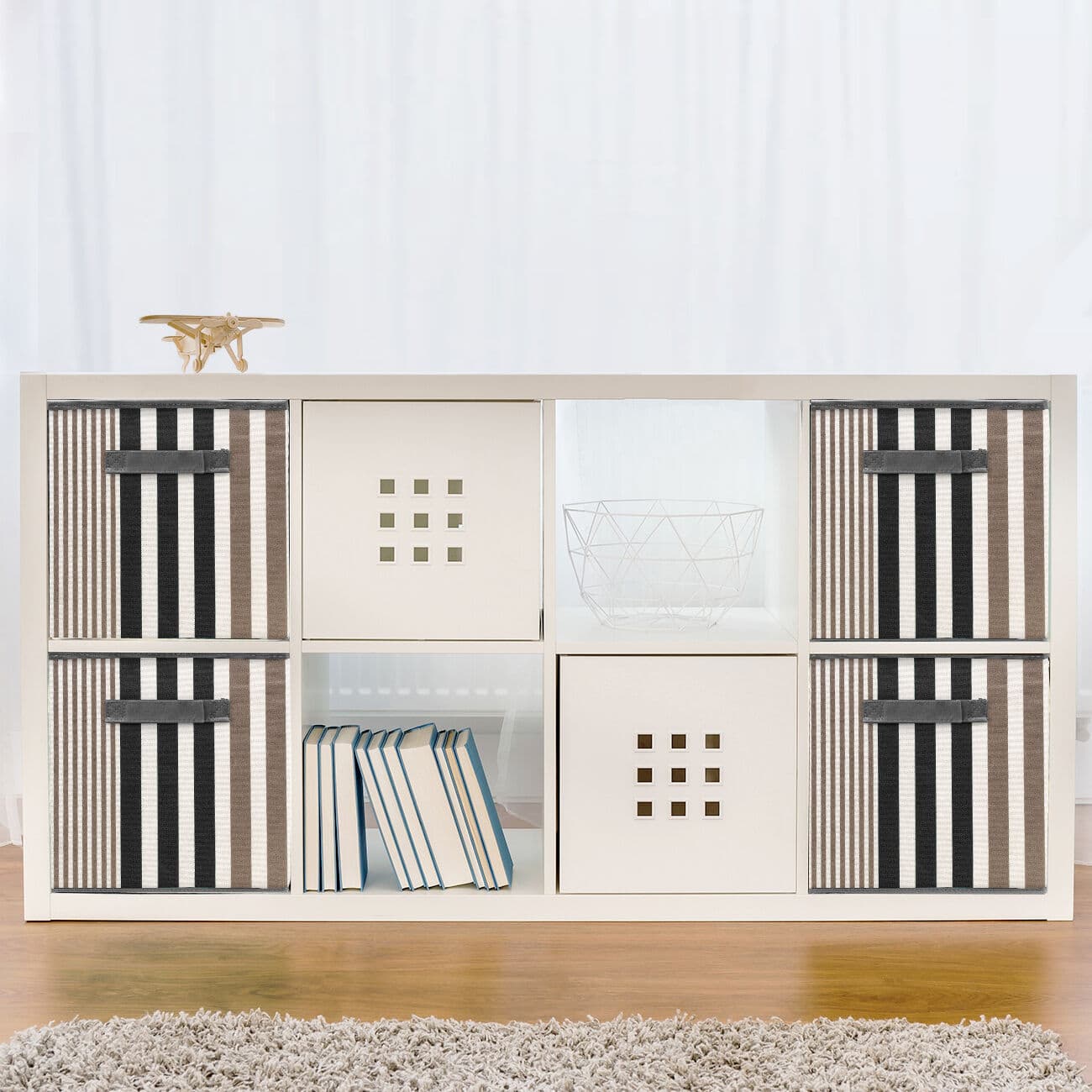 A white storage unit with black and white striped baskets.