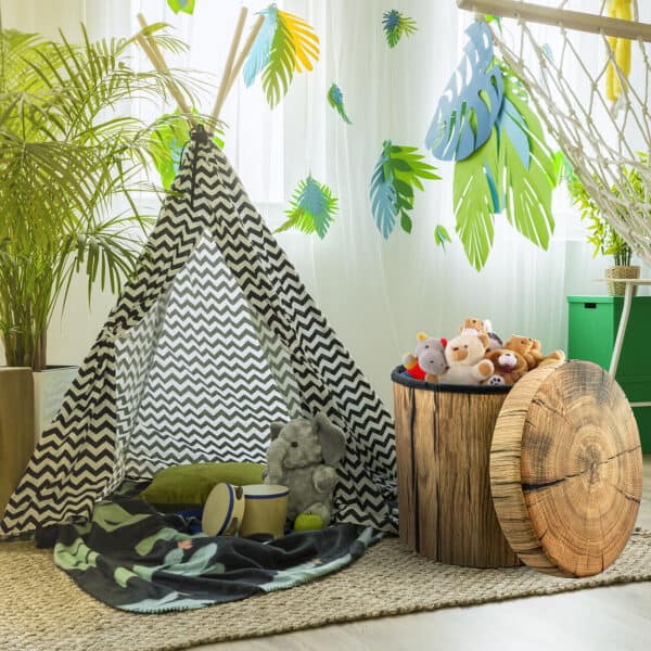 A children's room with a teepee, stuffed animals and a hammock.
