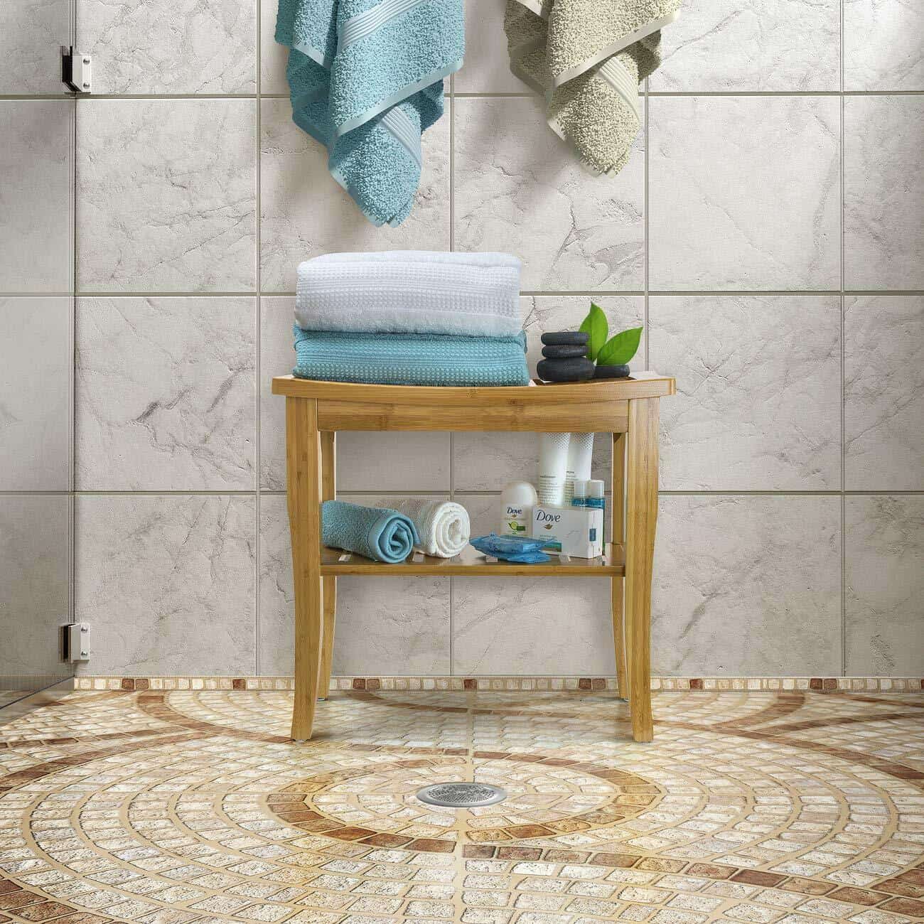 A bathroom with a bench and towels on a tiled floor.