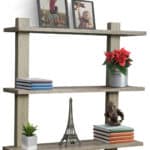 A wooden shelf with pictures and a vase on it.