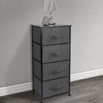 A grey dresser with four drawers and a lamp.