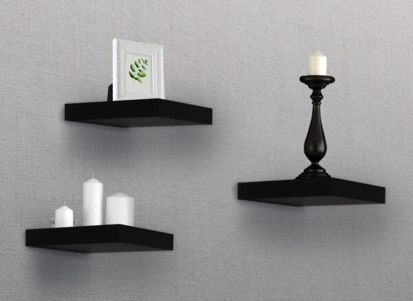 Three black shelves with candles and vases on them.