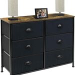 A black dresser with drawers and a picture on it.