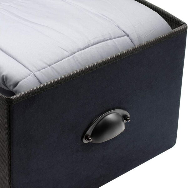 A black storage box with a bed inside of it.
