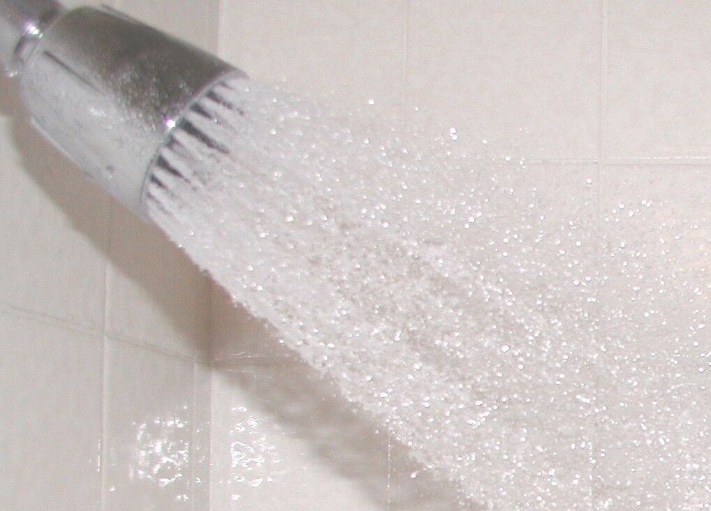 A shower head with water coming out of it.
