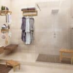 A bathroom with a glass shower stall and a wooden bench.