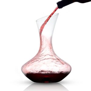 A red wine is being poured into a decanter.