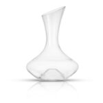 A clear glass decanter on a white surface.