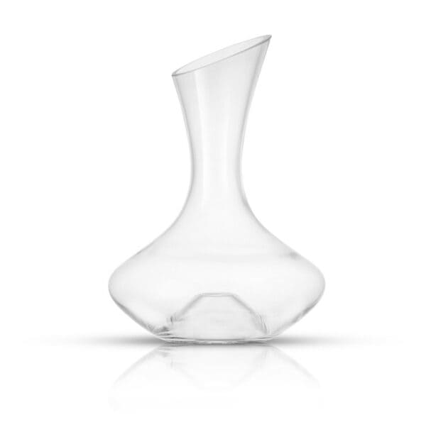 A clear glass decanter on a white surface.