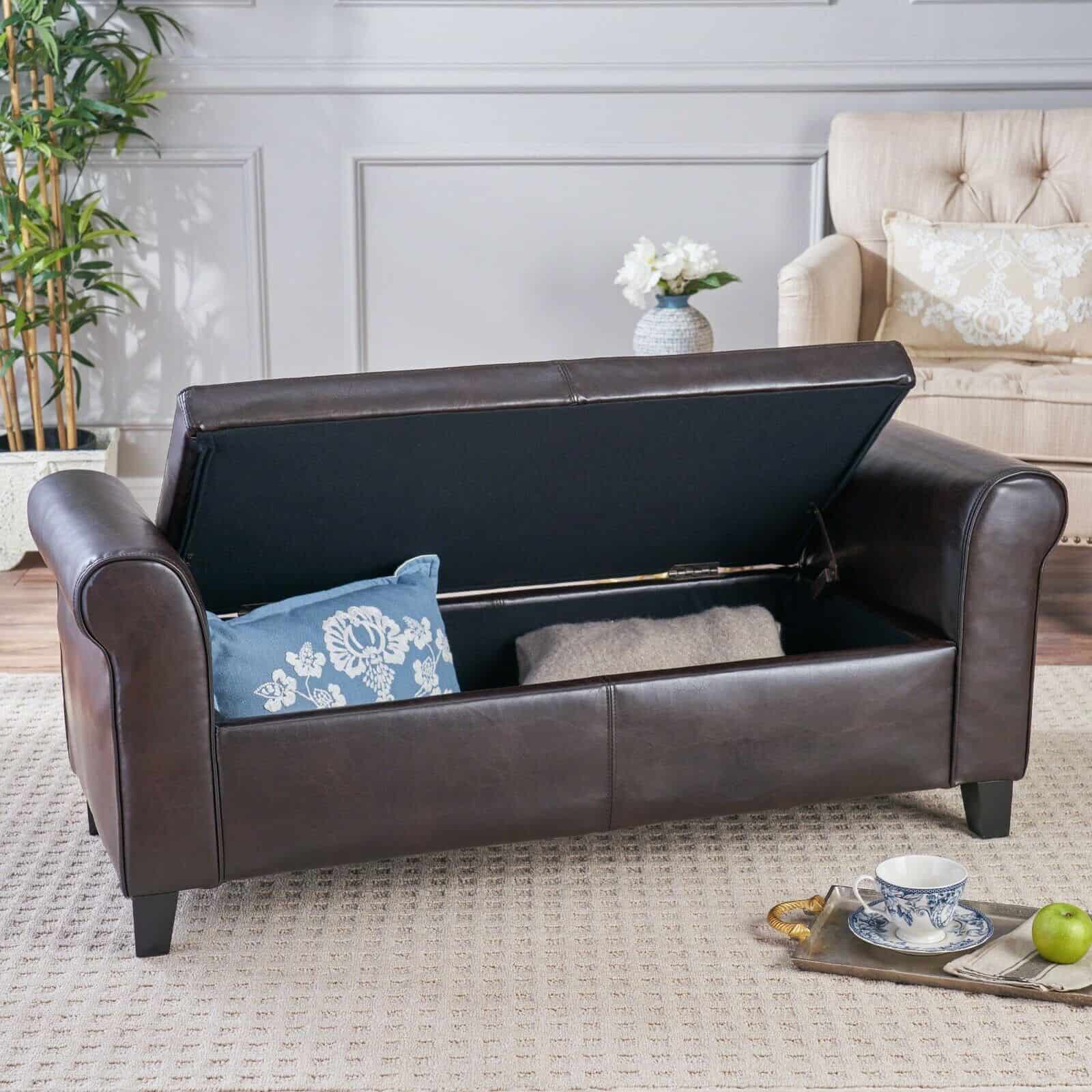 A brown leather storage bench in a living room.
