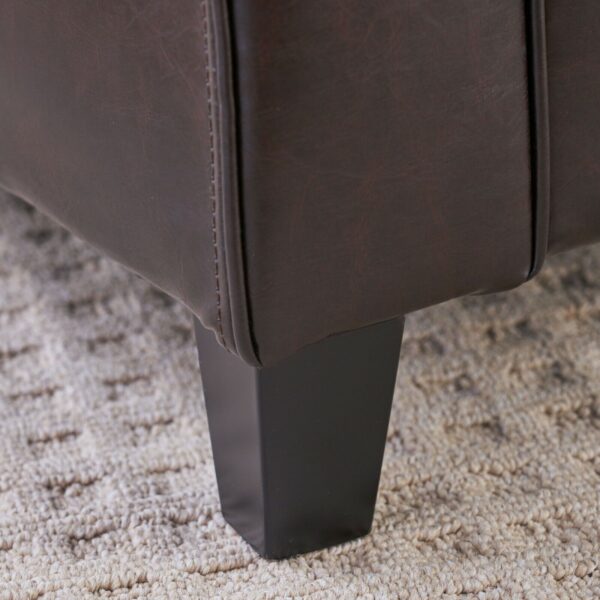 A close up of the legs of a brown leather chair.