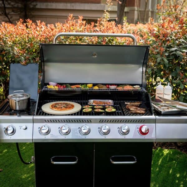 A black gas grill with pizza and other food on it.
