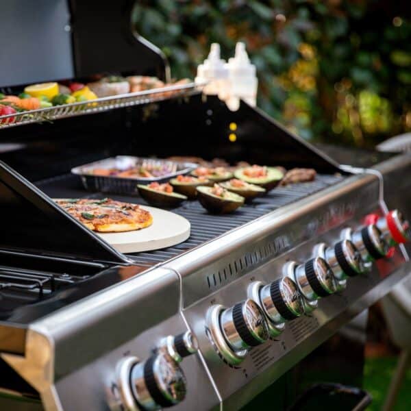 A grill with pizza and other food on it.