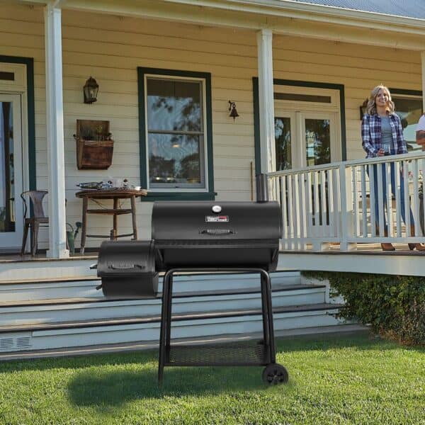 A woman is standing on the porch of a house with a bbq grill.