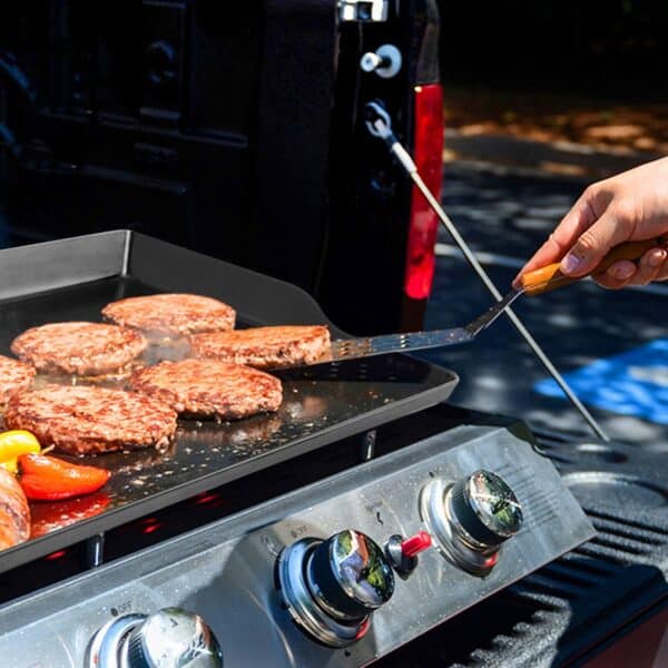 A person grilling hamburgers on a grill.