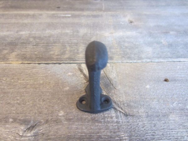 A black metal handle on a wooden surface.