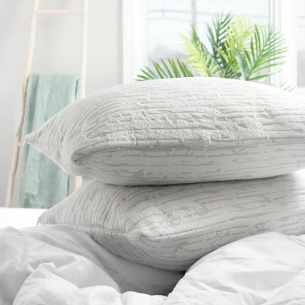 Two pillows stacked on top of each other on a bed.