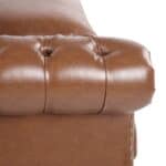 A close up of a brown leather chesterfield sofa.