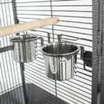 Two stainless steel bowls in a bird cage.