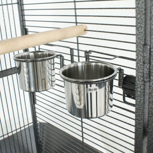 Two stainless steel bowls in a bird cage.
