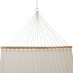 A white hammock hanging from a wooden frame.