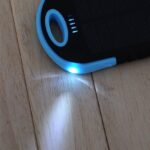 A solar powered power bank on a wooden floor.