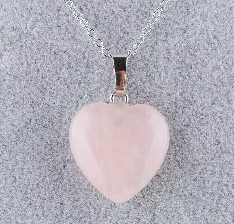A rose quartz heart pendant on a silver chain.