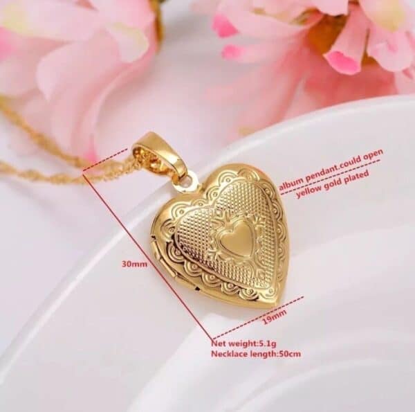 A gold heart locket necklace on a plate.