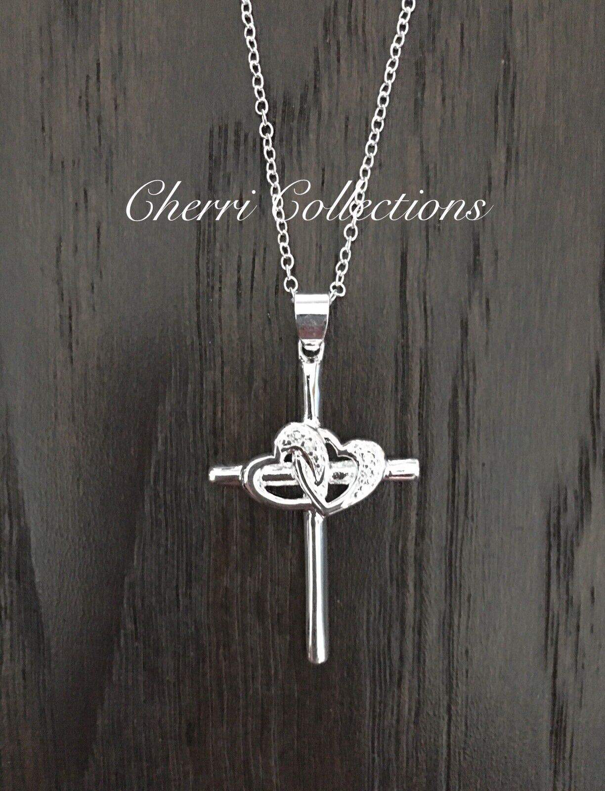 A silver cross necklace with a heart on it.