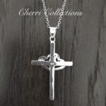 A sterling silver cross necklace on a wooden table.