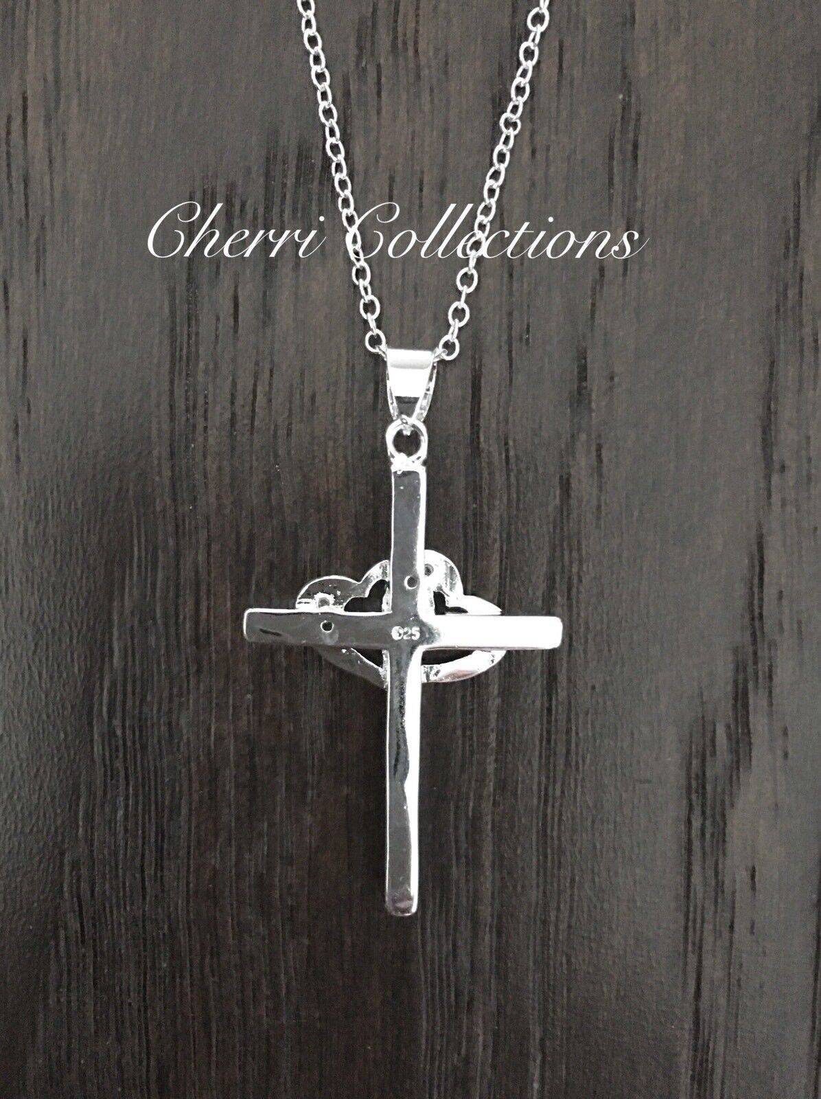 A sterling silver cross necklace on a wooden table.