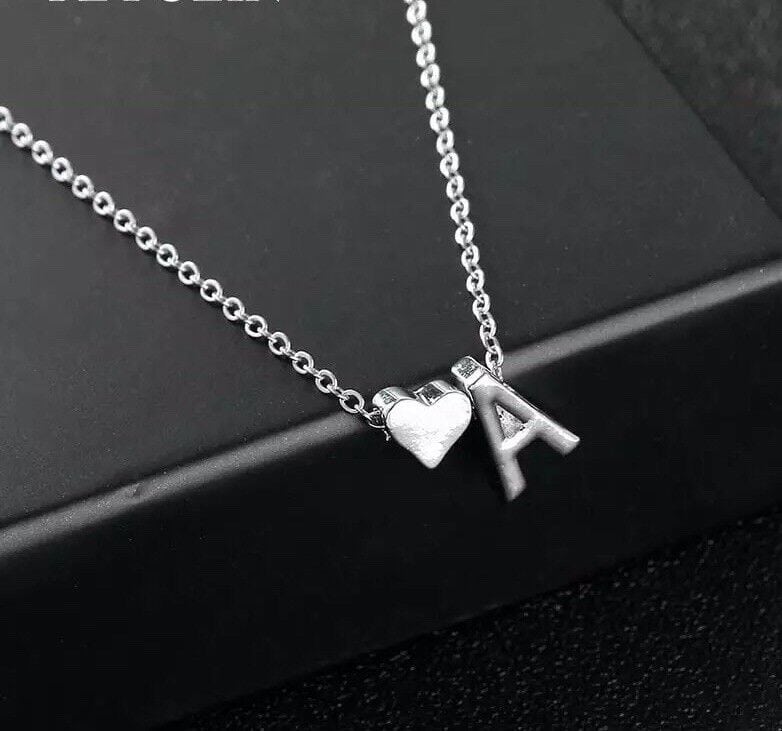 A silver necklace with an initial and a heart.