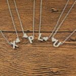 Four necklaces with the letters x, l, u and lu on them.