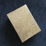 A gold box with a pattern on it.