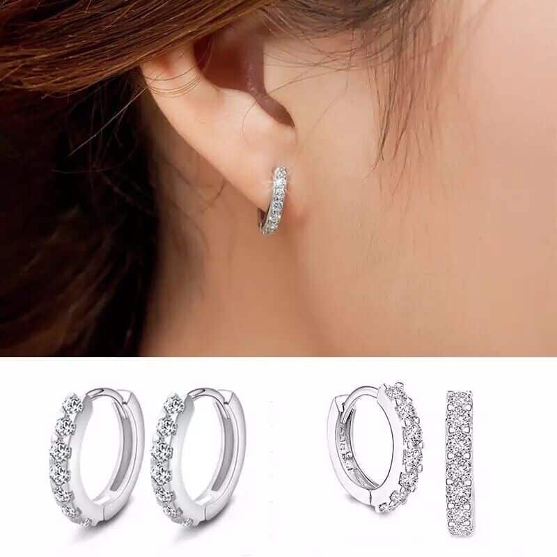A woman's ear with a pair of hoop earrings.